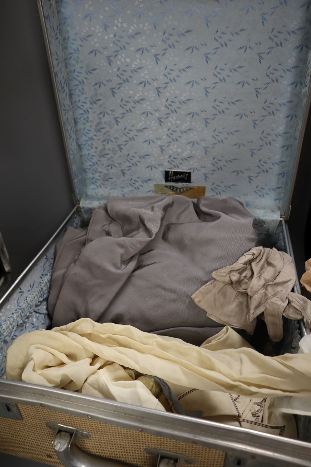 A Harrods suitcase containing 1900-40s cream chiffon and silk blouses, etc and a petit point bag